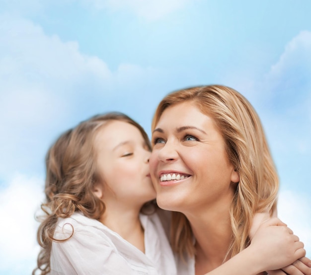 concepto de familia, niño y felicidad - abrazando a madre e hija