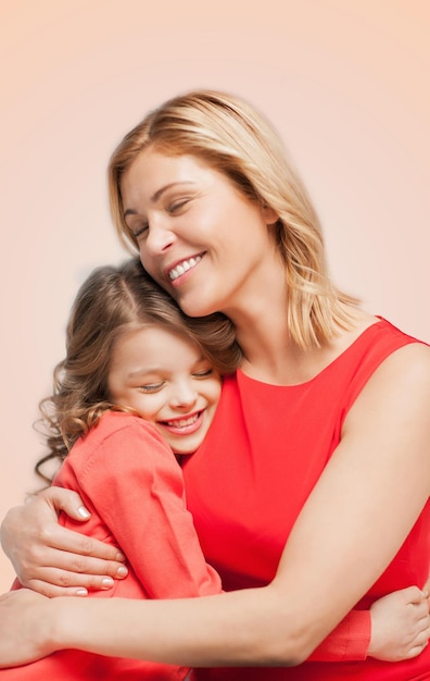 concepto de familia, niño y felicidad - abrazando a madre e hija