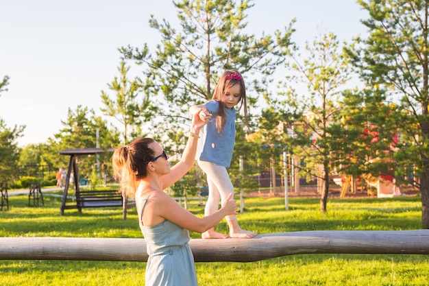 Foto concepto de familia y niño, madre e hija caminando y jugando en el parque y disfrutando del