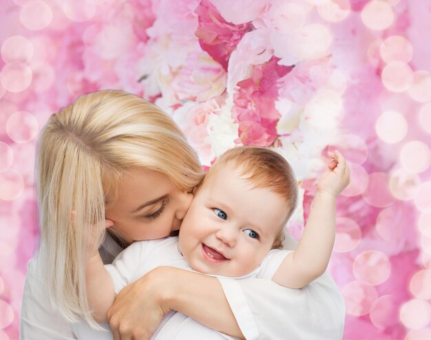 concepto de familia, niño y paternidad - madre feliz besando a un bebé sonriente