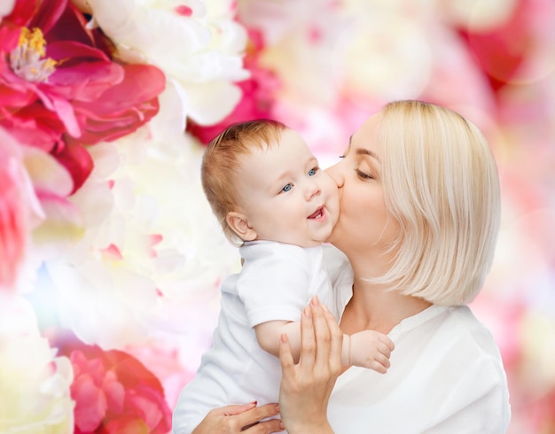 concepto de familia, niño y paternidad - madre feliz besando a un bebé sonriente