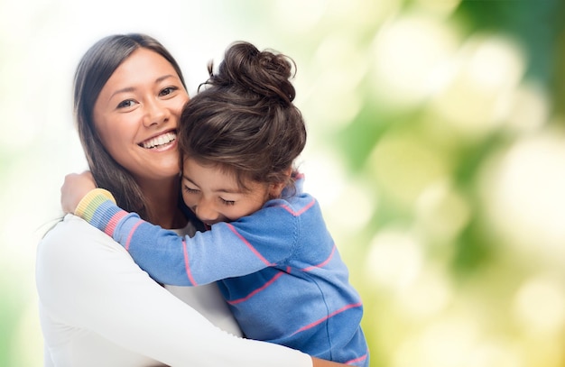 concepto de familia, niños y gente feliz - abrazando a madre e hija