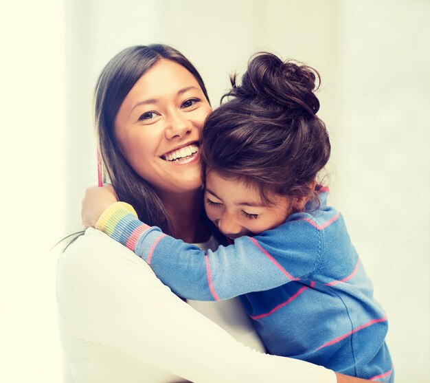 concepto de familia, niños y gente feliz - abrazando a madre e hija