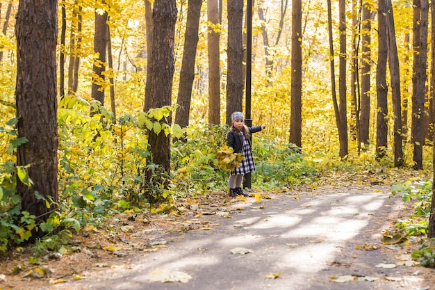 Concepto de familia, niños y temporada - niña niño feliz caminando en el parque de otoño.