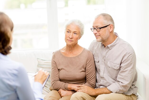 concepto de familia, relaciones, edad y personas - pareja mayor y psicólogo o trabajador social en casa