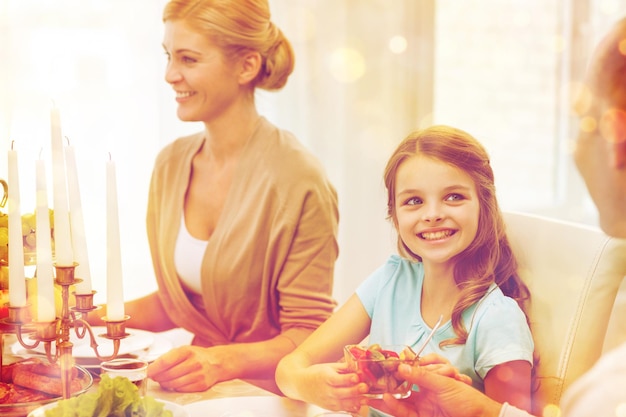 concepto de familia, vacaciones, generación y personas - familia sonriente cenando en casa