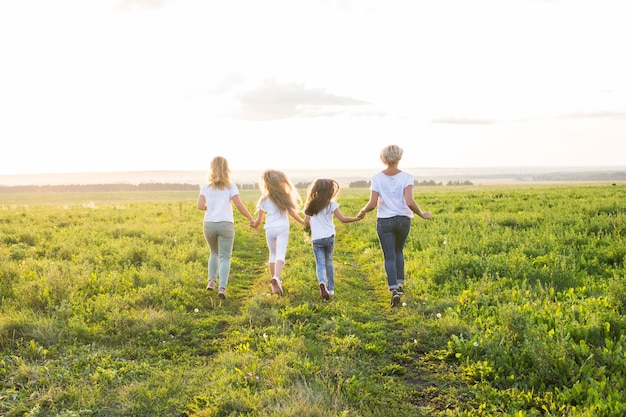 Concepto de familia, verano y vacaciones - Grupo de mujeres y niñas que se van en campo verde