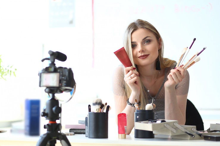 Foto concepto famoso del blog del video de la revisión del producto de maquillaje. hermosa grabación de vlogger tutorial de belleza. cosméticos, consejos de selección de herramientas de la bloguera. traducción en línea en casa o estudio