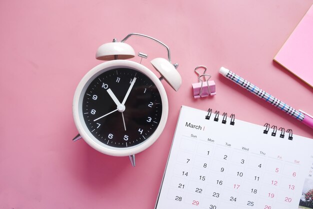 Foto concepto de fecha límite con calendario y despertador en rosa