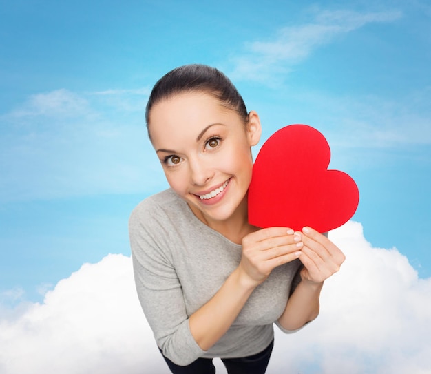 concepto de felicidad, amor y salud - mujer asiática sonriente con corazón rojo