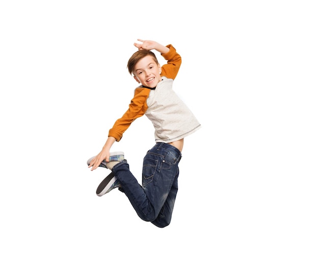 Foto concepto de felicidad, infancia, libertad, movimiento y personas - feliz niño sonriente saltando en el aire