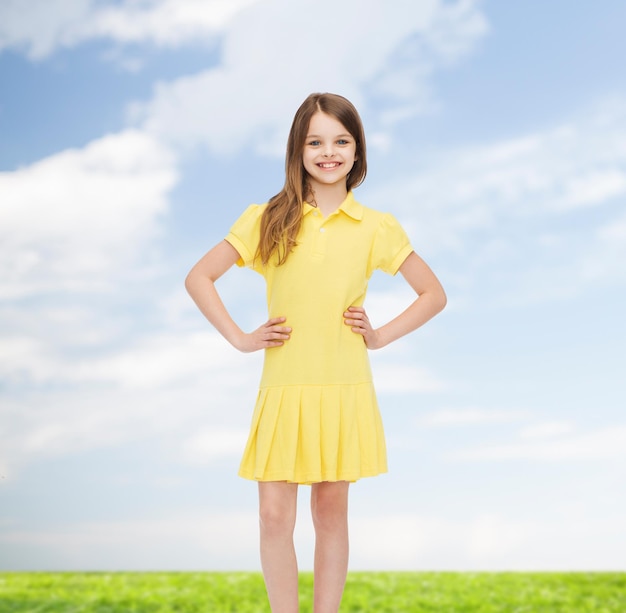 concepto de felicidad, infancia y personas - niña sonriente con vestido amarillo