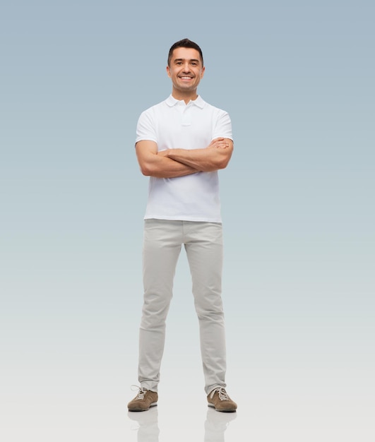 Foto concepto de felicidad y personas - hombre sonriente con los brazos cruzados sobre fondo gris