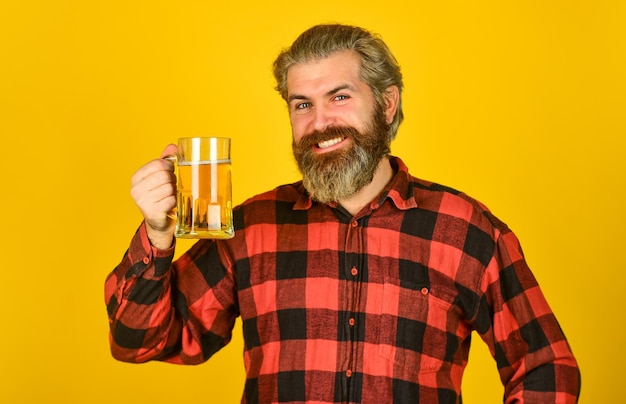 Concepto de feliz cumpleaños Hacer un sorbo Celebrar con alcohol Agregando alegría en la vida Hombre maduro con barba sostiene un vaso de cerveza Ocio y celebración Hombre bebiendo cerveza en el pub Cervecería Cervecería Hipster bebe cerveza