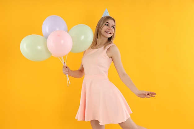 Concepto de feliz cumpleaños mujer joven sobre fondo amarillo