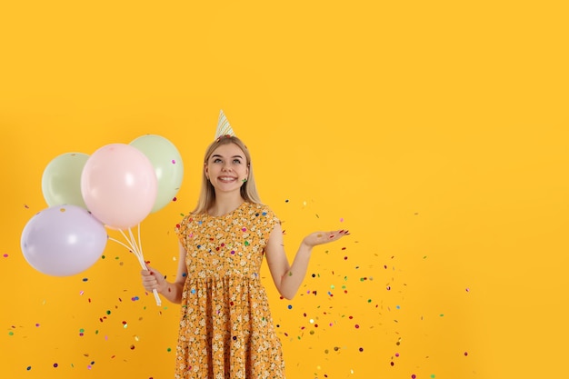 Concepto de feliz cumpleaños mujer joven sobre fondo amarillo