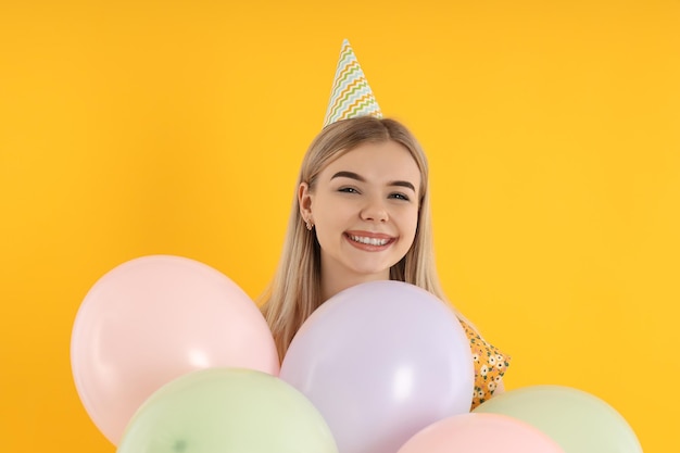 Concepto de feliz cumpleaños mujer joven sobre fondo amarillo