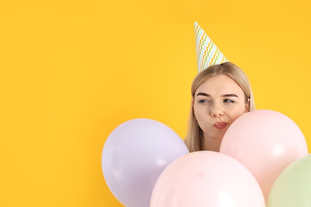 Concepto de feliz cumpleaños mujer joven sobre fondo amarillo