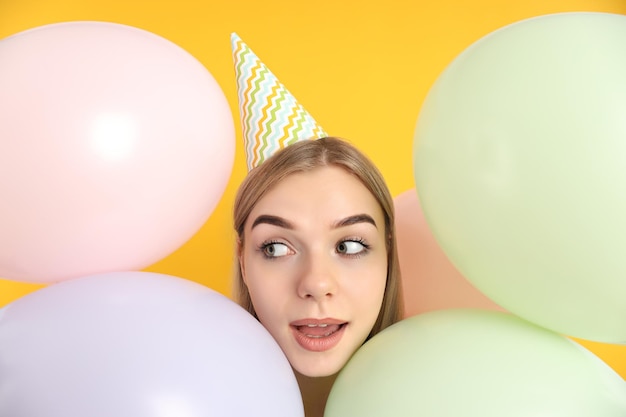 Concepto de feliz cumpleaños mujer joven sobre fondo amarillo