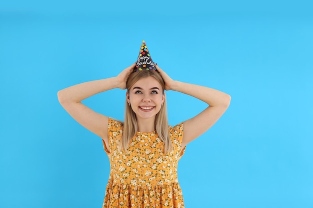 Concepto de feliz cumpleaños con mujer joven sobre fondo azul.