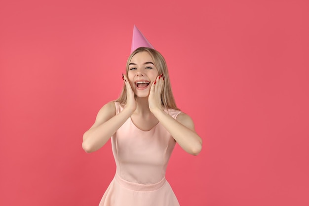 Concepto de feliz cumpleaños mujer joven sobre fondo rosa