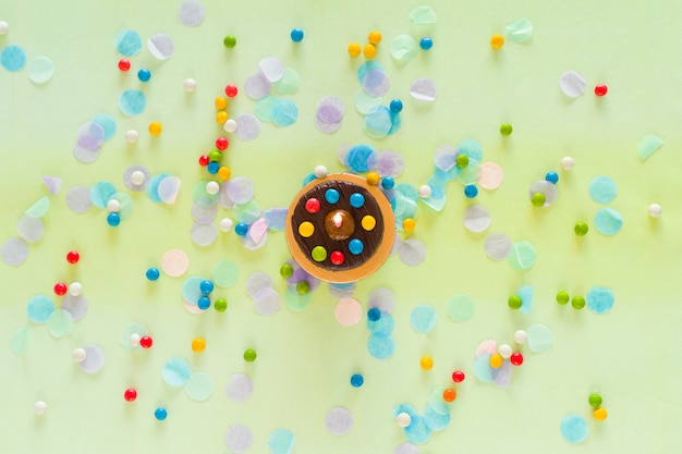 Concepto de feliz cumpleaños. Pastel, confeti y artículos de fiesta esparcidos sobre la mesa. Vista superior