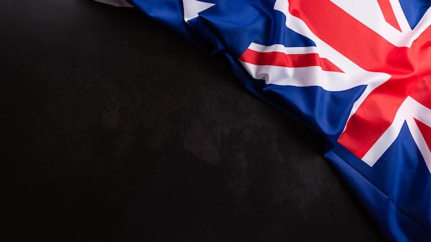 Concepto de feliz día de Australia. Bandera australiana sobre fondo de piedra oscura. 26 de enero.