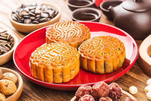 Foto concepto del festival del medio otoño, pasteles de luna tradicionales en mesa con taza de té.