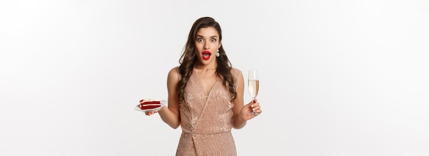 Concepto de fiesta y celebración mujer elegante con vestido de glamour de labios rojos bebiendo champán y comiendo