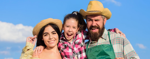 Foto concepto de fiesta de la cosecha. beneficios de la vida en el campo. padres e hijas agricultores de estilo rústico sobre fondo de cielo azul. familia feliz alegre agricultores jardineros. agricultores familiares orgullosos de la cosecha de otoño.