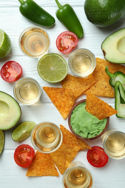 Concepto de fiesta con tequila, guacamole y papas fritas.