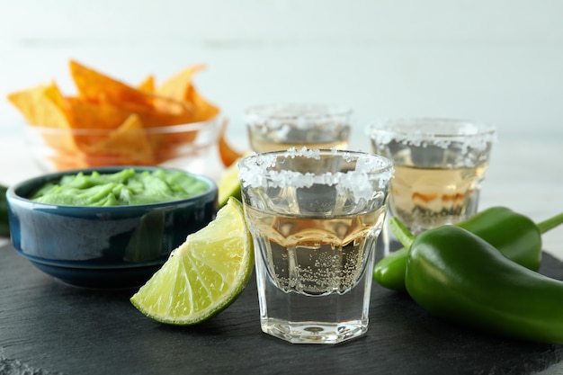 Concepto de fiesta con tequila, guacamole y papas fritas.