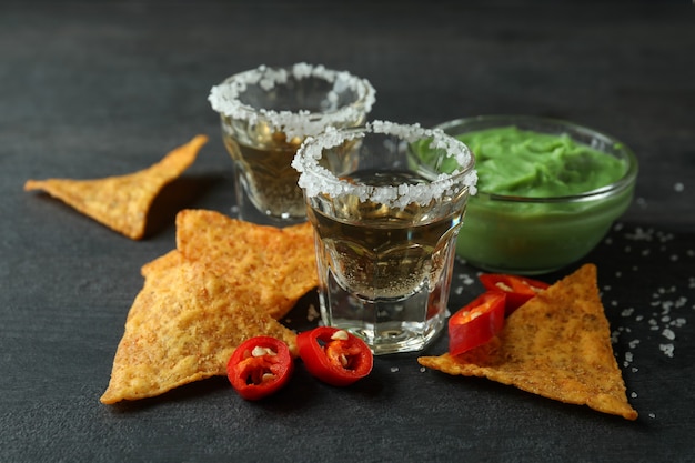 Concepto de fiesta con tequila, guacamole y papas fritas.