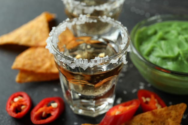 Concepto de fiesta con tequila, guacamole y papas fritas.