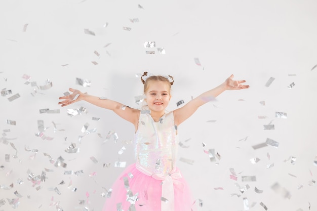 Concepto de fiesta, vacaciones, cumpleaños, año nuevo y celebración - Niño lindo lanzando confeti.