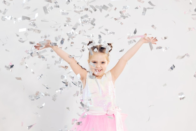 Concepto de fiesta, vacaciones, cumpleaños, año nuevo y celebración - Niño lindo lanzando confeti.