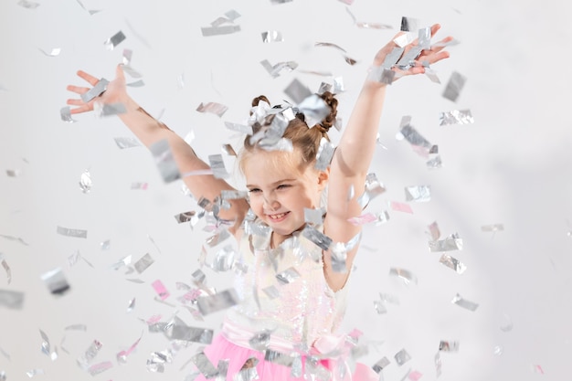 Concepto de fiesta, vacaciones, cumpleaños, año nuevo y celebración - Niño lindo lanzando confeti.