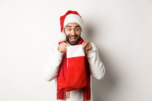 Concepto de fiesta y vacaciones de Navidad con joven guapo