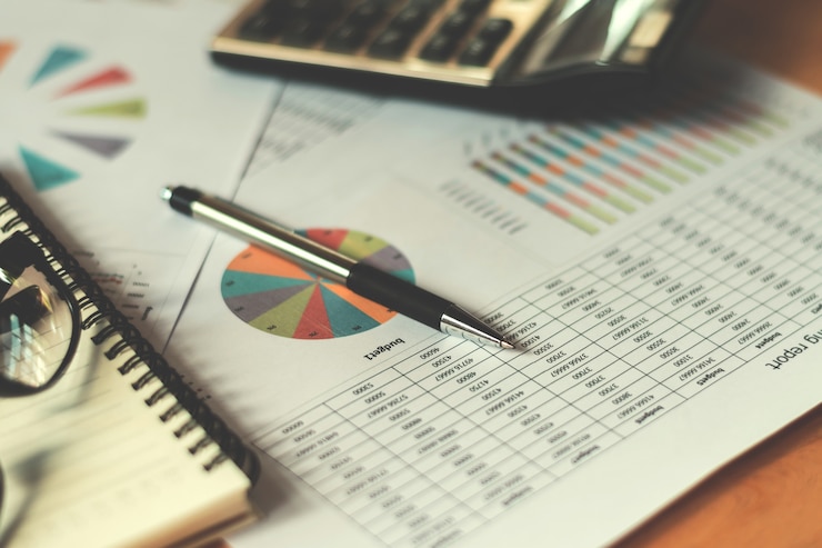 Foto concepto financiero empresarial con pluma calculadora e informe contable en la oficina
