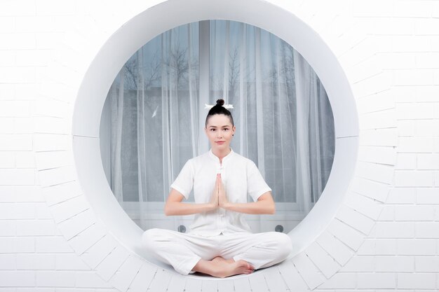 Concepto de fitness, deporte, entrenamiento y estilo de vida - mujer joven haciendo ejercicio de yoga. Retrato de joven hermosa en ropa deportiva blanca haciendo práctica de yoga.Mujer haciendo ejercicio de estiramiento