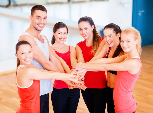 concepto de fitness, deporte, entrenamiento, éxito y estilo de vida - grupo de gente feliz en el gimnasio celebrando la victoria