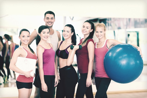 concepto de fitness, deporte, entrenamiento, gimnasio y estilo de vida - grupo de personas sonrientes en el gimnasio