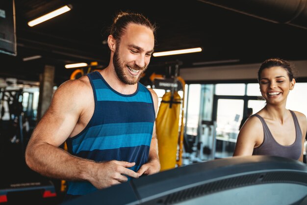 Concepto de fitness, deporte, entrenamiento, gimnasio y estilo de vida. Grupo de personas sonrientes haciendo ejercicio en el gimnasio