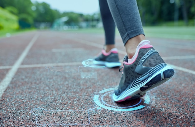 concepto de fitness, deporte, entrenamiento, personas y estilo de vida - cierre de pies de mujer corriendo en pista desde atrás con hologramas futuristas
