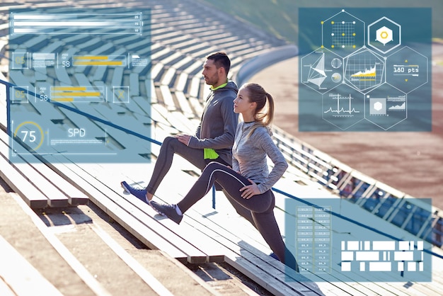 Foto concepto de fitness, deporte y personas: pareja estirando la pierna en las gradas del estadio