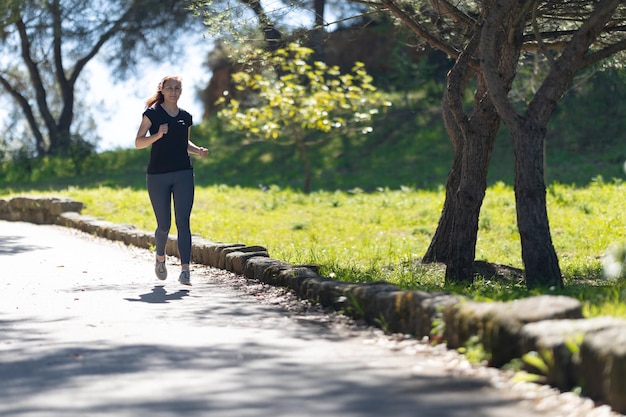 Concepto de fitness una mujer adulta corriendo en el parque verde