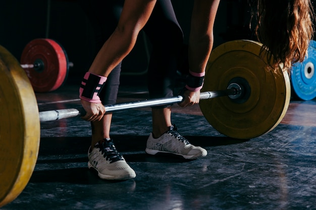 Foto concepto de fitness con mujer y barra de pesas