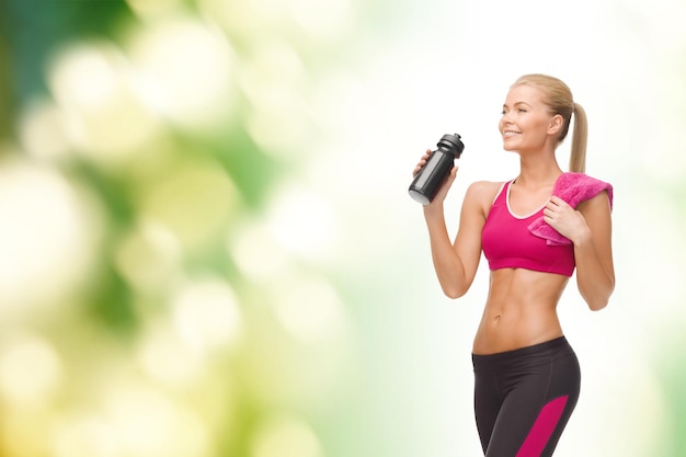 concepto de fitness, salud y dieta - mujer deportiva sonriente bebiendo agua de una botella de deportista