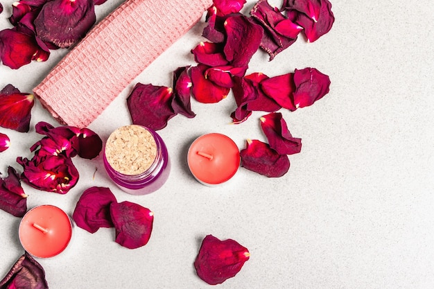 Concepto floral y spa con pétalos de rosas secas, velas aromáticas y toalla suave