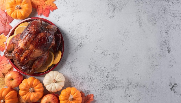 Concepto de fondo de la cena de acción de gracias con pavo asado y platos de todos los lados, hojas de otoño, calabaza y decoración otoñal estacional sobre fondo de piedra, vista superior, espacio de copia.